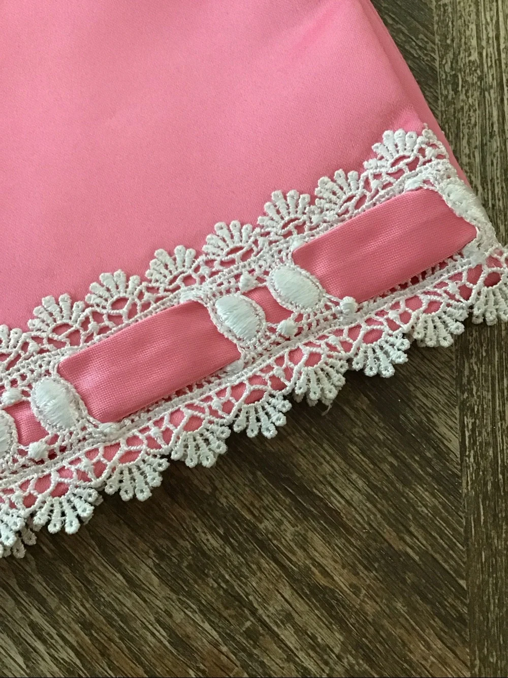 Table runner features a decorative white lace and ribbon trim
